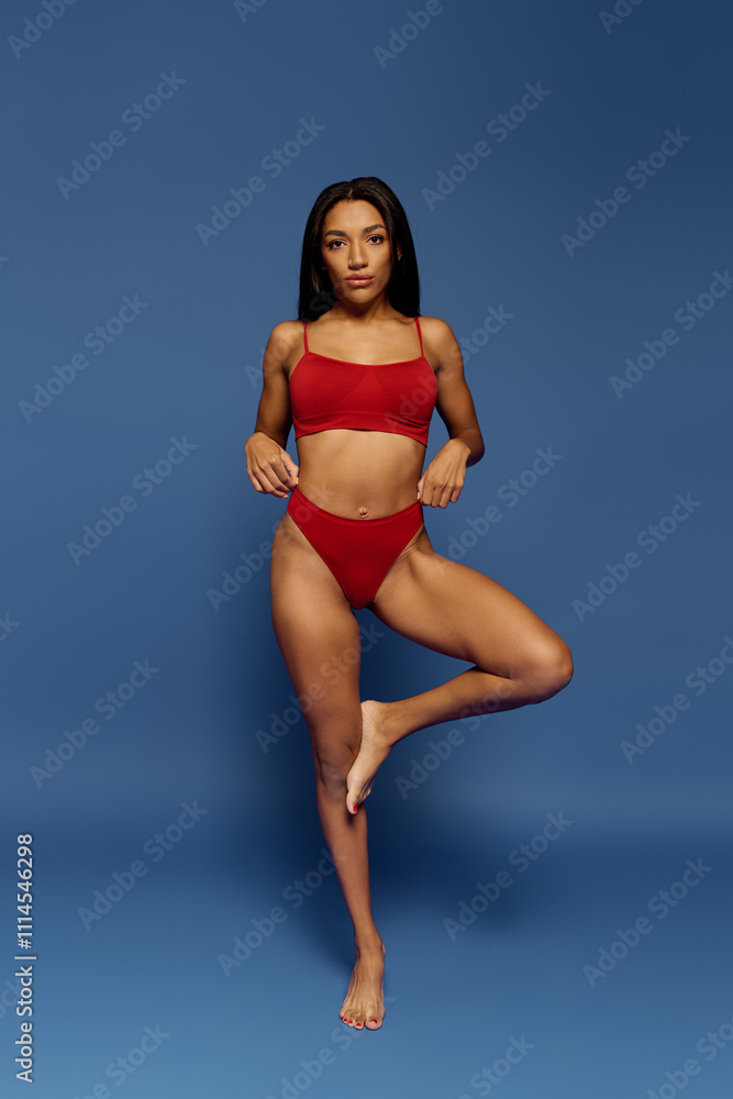 Fototapeta premium A confident young African American woman models stylish underwear in a studio setting.