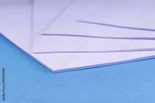 Several sheets of white bond paper on a light blue background
