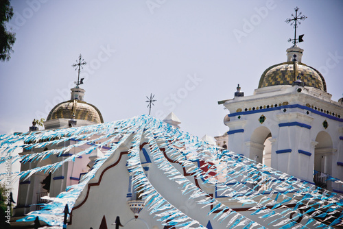 Mexican church entrance facade and festive flags, personal perspective view. photo