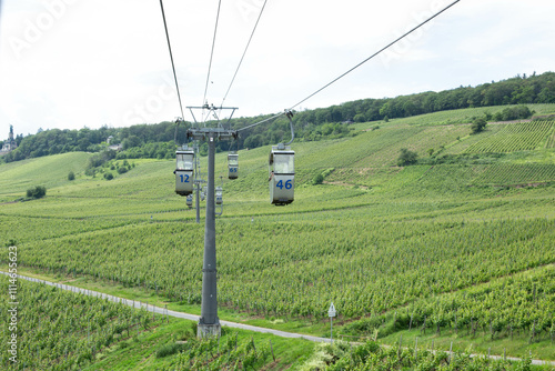 Cable car on rope of cableway from Rudesheim am Rhein town to Roseneck mount above vineyards fields of river Rhine Valley hills, blue clear sky background in sunny summer day, State of Hesse, Germany photo