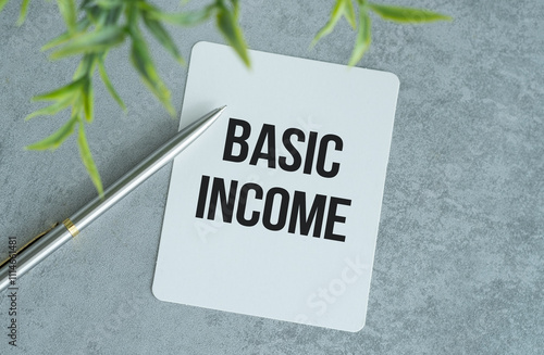 Basic income text on paper notepad, concept background photo