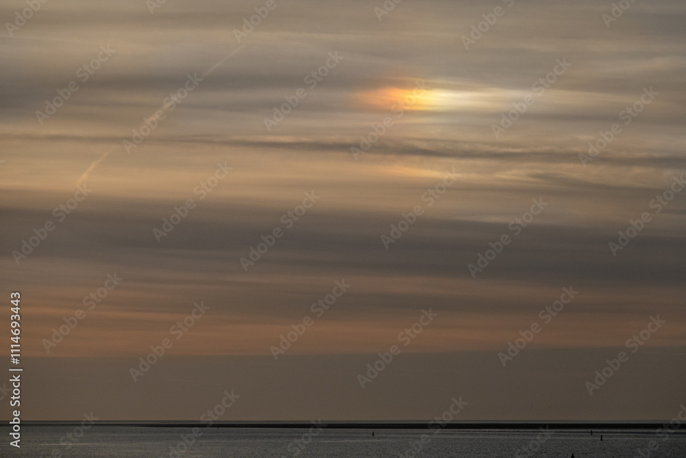 Naklejka premium Sundog above sea, caused by refraction of sunlight by ice crystals in the atmosphere