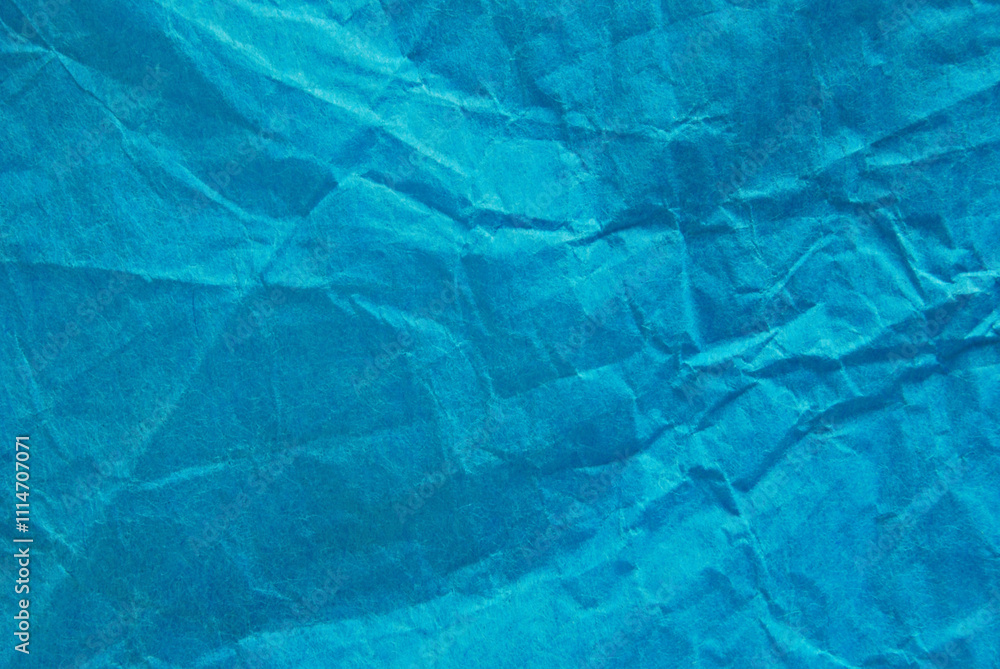 Obraz premium A sheet of wrinkled glossy blue paper texture as background