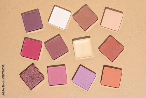 Colorful makeup powders organized on a beige background photo