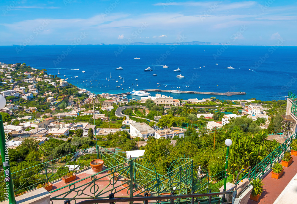 view of Capri, including the Gardens of Augustus, with vibrant flowers, lush greenery, and panoramic vistas of the coastline and iconic Faraglioni rocks.
