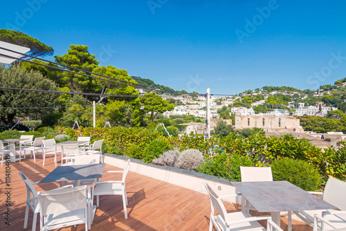 view of Capri, including the Gardens of Augustus, with vibrant flowers, lush greenery, and panoramic vistas of the coastline and iconic Faraglioni rocks.
