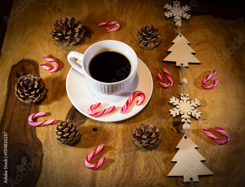 A white coffee cup with a black coffee sits on a wooden table. Christmas coffee break