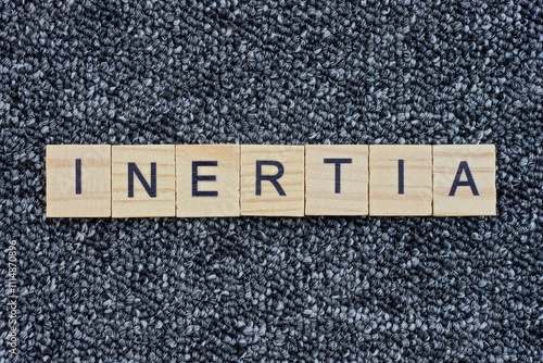 Canvastavla text the word inertia from wooden small letters with black font on an gray table