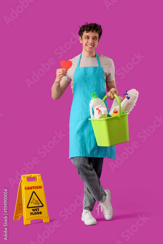 Happy male janitor with buc...