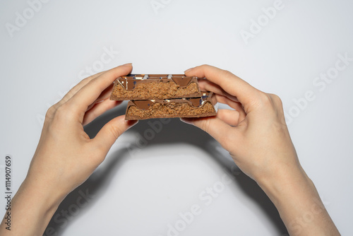 Trend Dubai chocolate bar with nutella and kataifi dough filling in woman's hands. Confectionery and sweets. photo