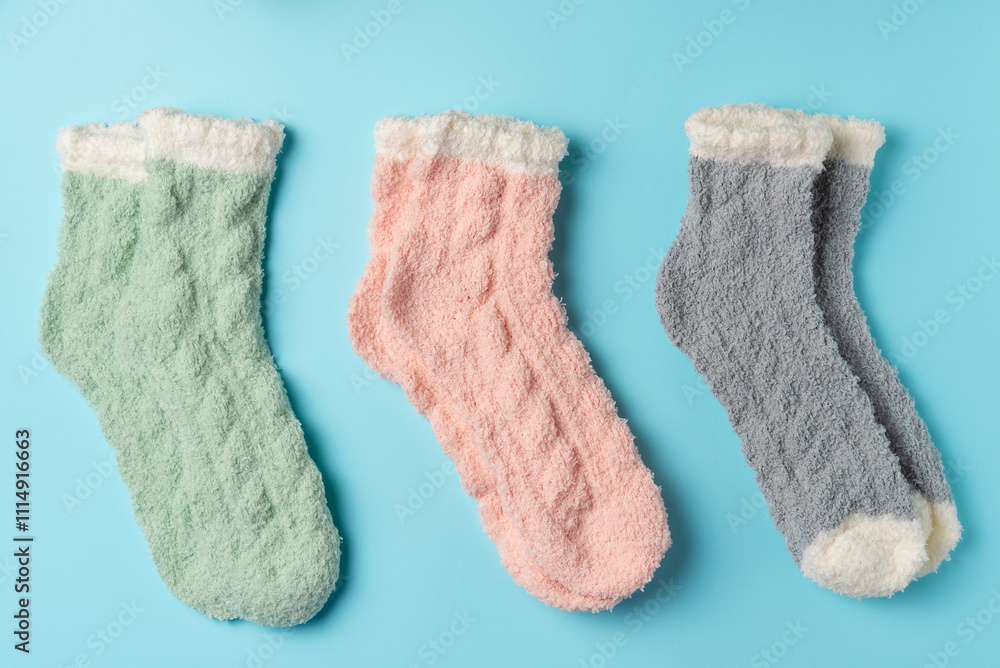 Different warm socks on a blue background. Flat lay, top view Different warm socks on a blue background. Flat lay, top view