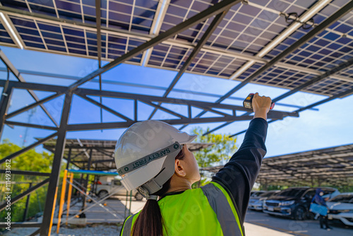 ngineer inspecting solar panel installation on a modern structure, pointing to details while holding a laptop, highlighting sustainable energy solutions, efficient design, and renewable innovation. photo