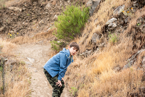 niño jugando y viviendo aventuras en la montaña photo