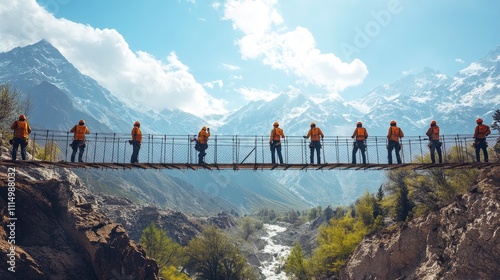 A group of climbers traverses a suspension bridge in a mountainous landscape.