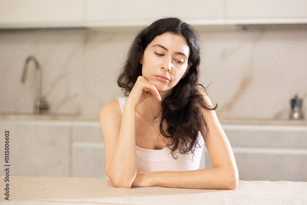 Young upset woman in casual clothes posing in kitchen at home Young upset woman in casual clothes posing in kitchen at home