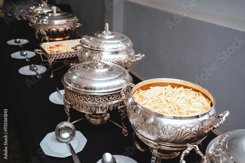 a buffet table with silver plates with food