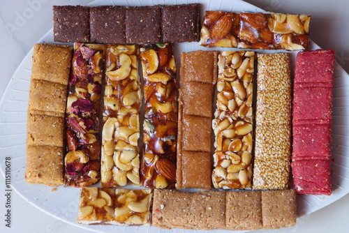 Chikki, Indian sweet (brittle) made from nuts and jaggery orsugar, groundnut (peanut) chikki, dry fruits, sesamum, fruit crush etc. photo