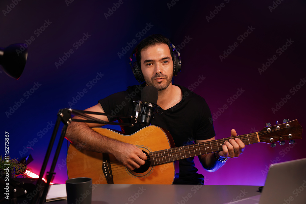 Obraz premium Host channel of smart influencer in creative audio on live streaming to fanclub with sing with play guitar music blogger using headset and mic social media online at neon light modern studio. Surmise.