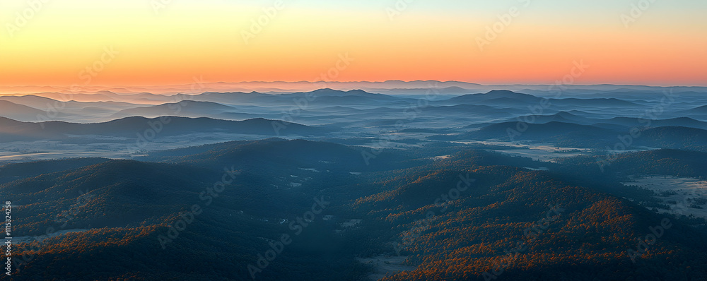 Fototapeta premium Sunrise over misty mountain range.