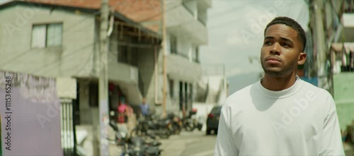  A young black Hispanic man walking through the neighborhood