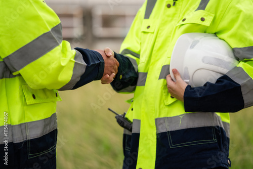 Engineer worker hand shaking to colleagues team for success work at construction site of petroleumchemical industry or refinery oil plant factory