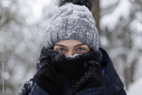 Closeup of young woman in scarf and hat covered in snow photo