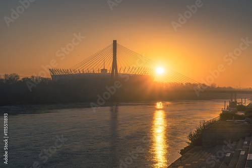 Wschodzące słońce nad brzegiem Wisły w Warszawie. Widok na stadion Narodowy w stolicy photo