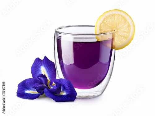 Glass cup of organic purple butterfly pea flower tea (blue pea, bluebellvine, cordofan pea, clitoria ternatea) with lemon isolated on white background.