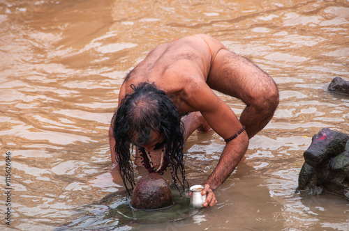 A Sadhu offering prayer in Godavari river during the Simhastha Kumbh Mela, India. photo