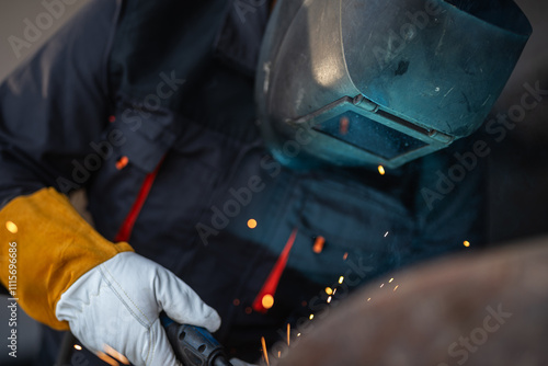 Industrial worker welding metal with sparks flying photo