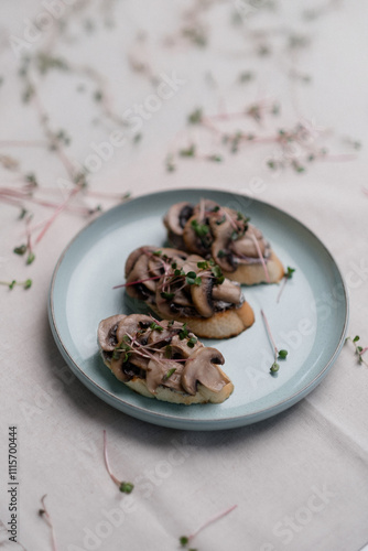 In the image, three slices of toasted bread are adorned with mushrooms, microgreens, and a creamy sauce. 
