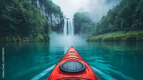 Fototapeta Naklejka Na Ścianę i Meble -  Vibrant red kayak gliding on a misty blue river in front of a waterfall
