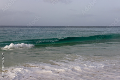 Beautiful turquoise waves of Atlantic Ocean on grey gloomy day in Cabo Verde.