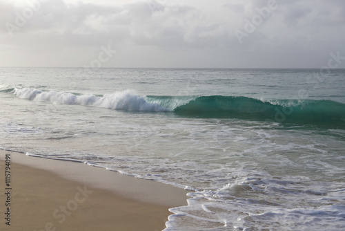 Beautiful turquoise waves of Atlantic Ocean on grey gloomy day in Cabo Verde.