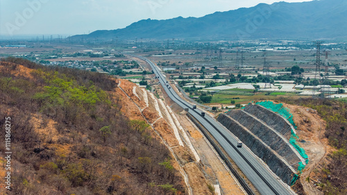 Asphalt highway road and green mountain with sky clouds at sunny. From Vinh Hao, Khanh Hoa to Phan Thiet, Vietnam photo