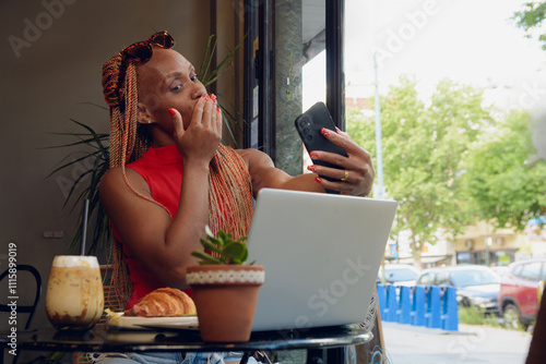 Young woman takes a selfie blowing a kiss with the phone