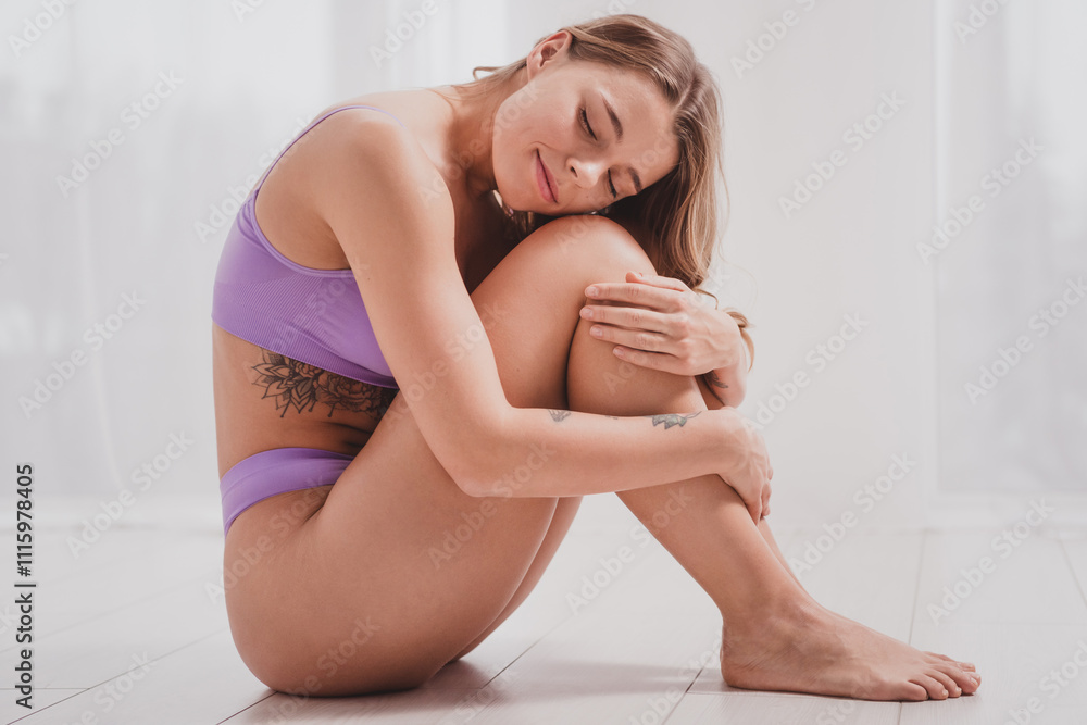 Obraz premium Full length photo of young lady posing model sit floor hug knees violet lingerie white room studio background no filter all body perfect