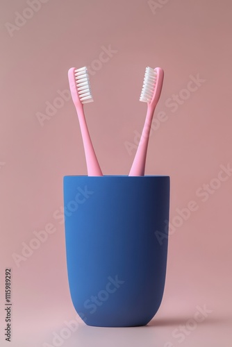 Two pink toothbrushes in a modern blue holder on a soft pink background, showcasing a minimalist bathroom aesthetic for personal care and hygiene products. photo