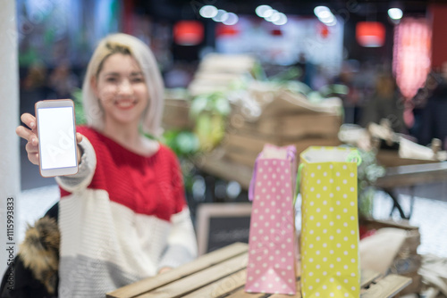 Wallpaper Mural Woman showing a smartphone screen in a lively indoor market. Torontodigital.ca