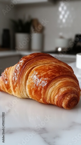 Freshly baked croissant on a marble countertop in a modern kitchen setting
