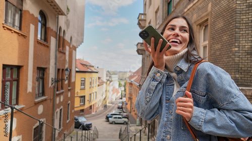 Woman using her smartphone in a colorful and sunny city environment.