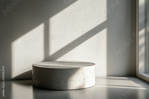 Minimalist round concrete stool placed in a sunlit modern interior with soft ...