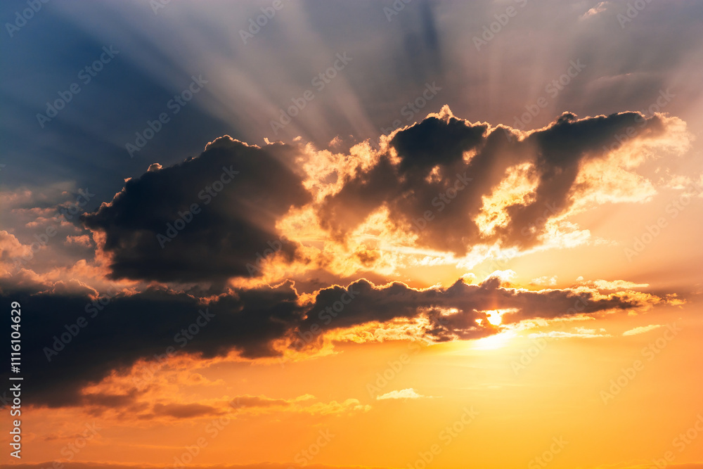 Fototapeta premium orange sunset with sunlight on cloudy sky. Background with sky with clouds in summer