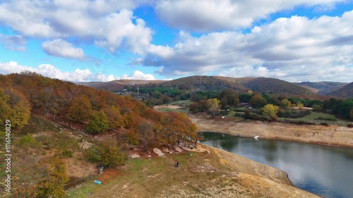 Autumn Colors Embrace a Serene Lakeside Landscape. A 4k ultrahd video autumn scene unfolds with vibrant fall foliage blanketing the rolling hills surrounding a tranquil lake. Omerli Sile Cekmekoy
 photo