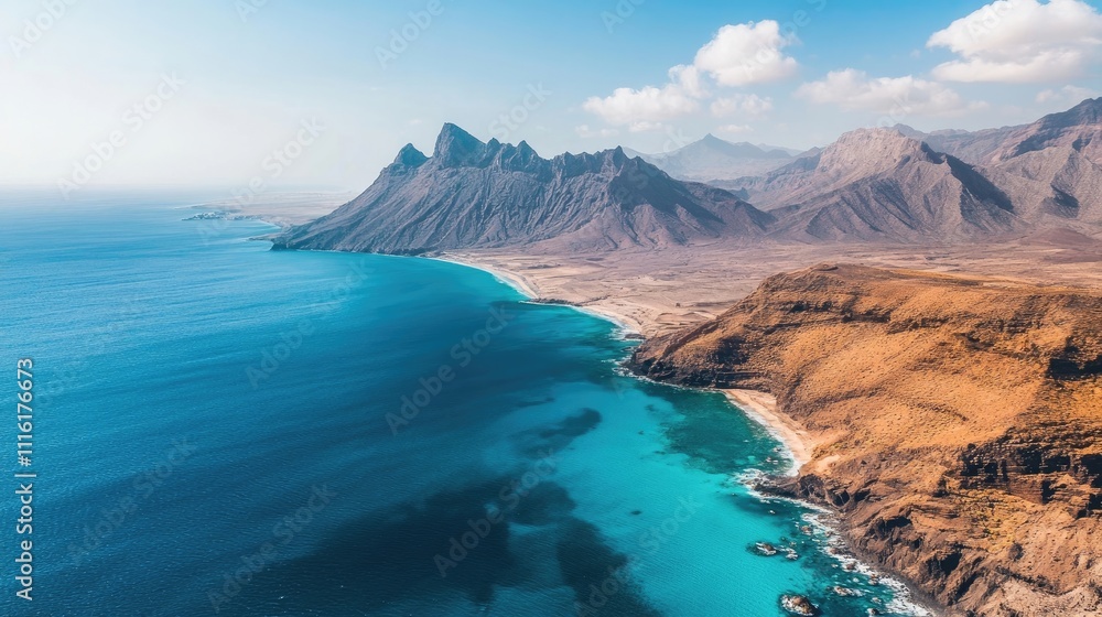 Fototapeta premium Mountainous coastline with clear blue water, ideal for capturing the beauty of nature. This image of the scenic mountainous coastline invites exploration and adventure.