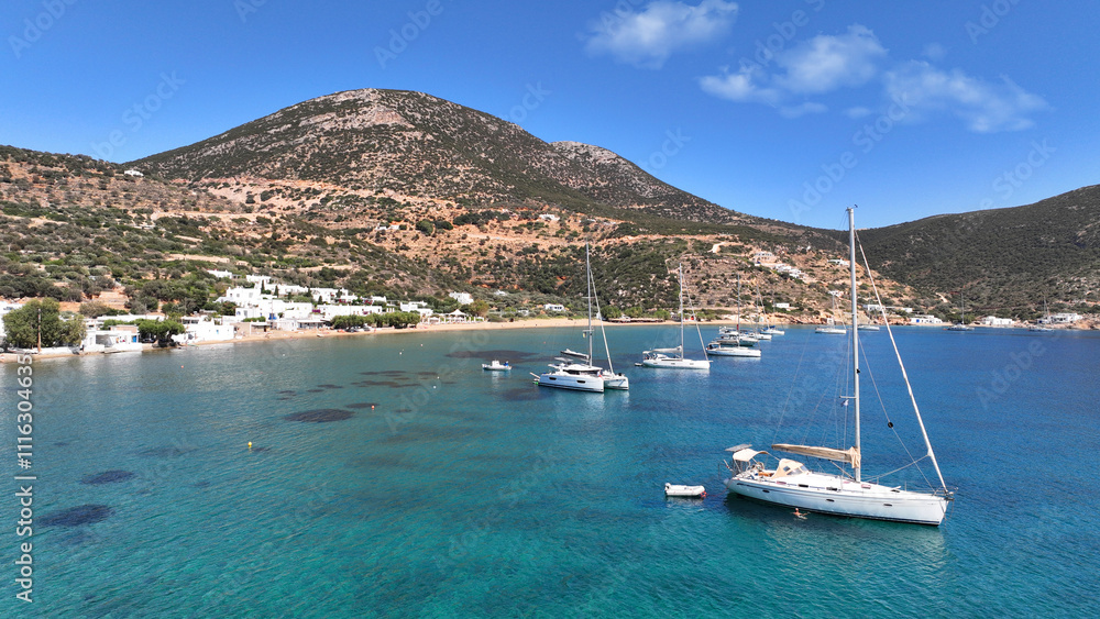 Obraz premium Aerial drone photo of picturesque seaside fishing village of Vathy featuring landmark chapel of Taxiarchis, Sifnos island, Cyclades, Greece