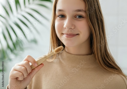 Girl promoting eco-friendly oral hygiene routine with a bamboo toothbrush, embracing sustainability photo