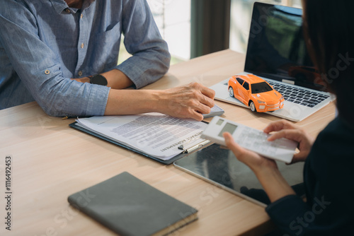 Auto Loan Consultation:  A close-up shot of a financial advisor and client reviewing car loan documents, signifying trust and financial planning. photo