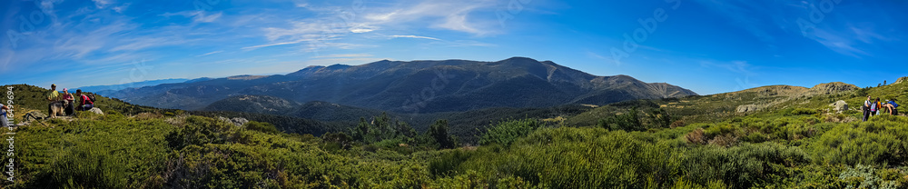 Obraz premium The path to the summit of Peñalara reveals stunning vistas of the surrounding mountains and lush vegetation. A hiker's paradise.