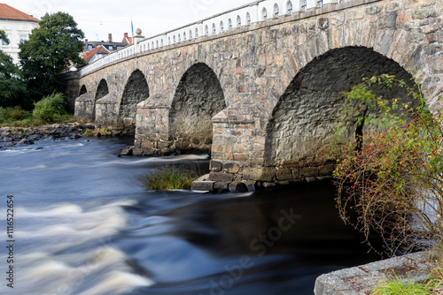 Stone arch bridge over river in long exposure in Falkenberg, Sweden